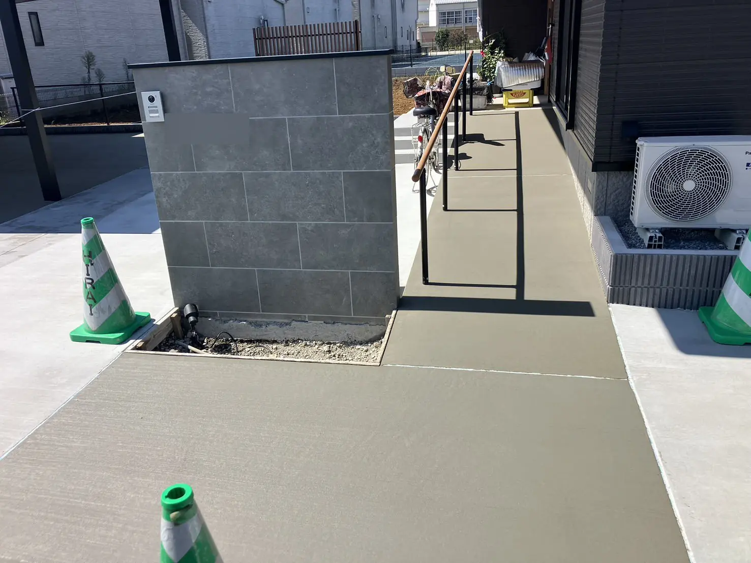 工事中。門柱の足元にライトを付け、スロープの土間コンクリートを打ったところ
